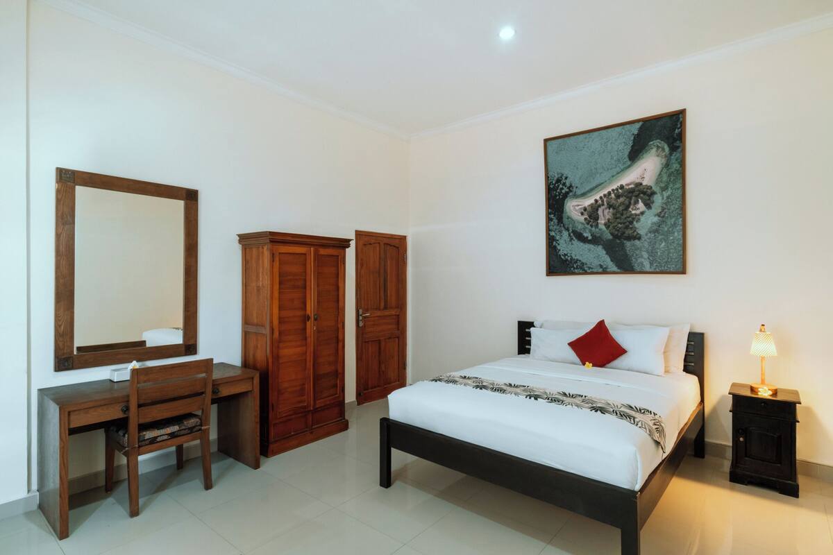 A bedroom with a bed, a desk, and two wardrobes.