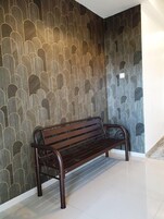 Un banco en un pasillo con un papel tapiz decorado.