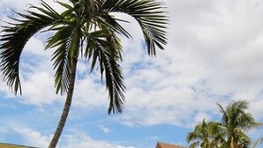 A pool area with lounge chairs and a building with balconies.