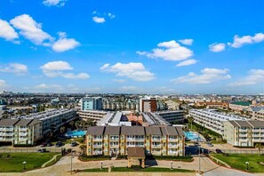 Un hotel de varios pisos con un patio central, múltiples balcones y una piscina.