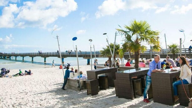 A beachside restaurant with outdoor seating and a view of the sea. - Vacation apartment small quiet oasis - forest edge location, central in Scharbeutz - House (Scharbeutz)