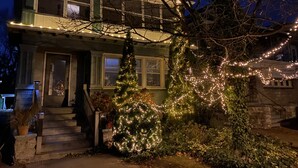 A two-story house with a porch, a staircase, and a Christmas tree decorated with lights. - FIRST FLOOR FLAT FOR BUSINESS OR PLEASURE (Buffalo)