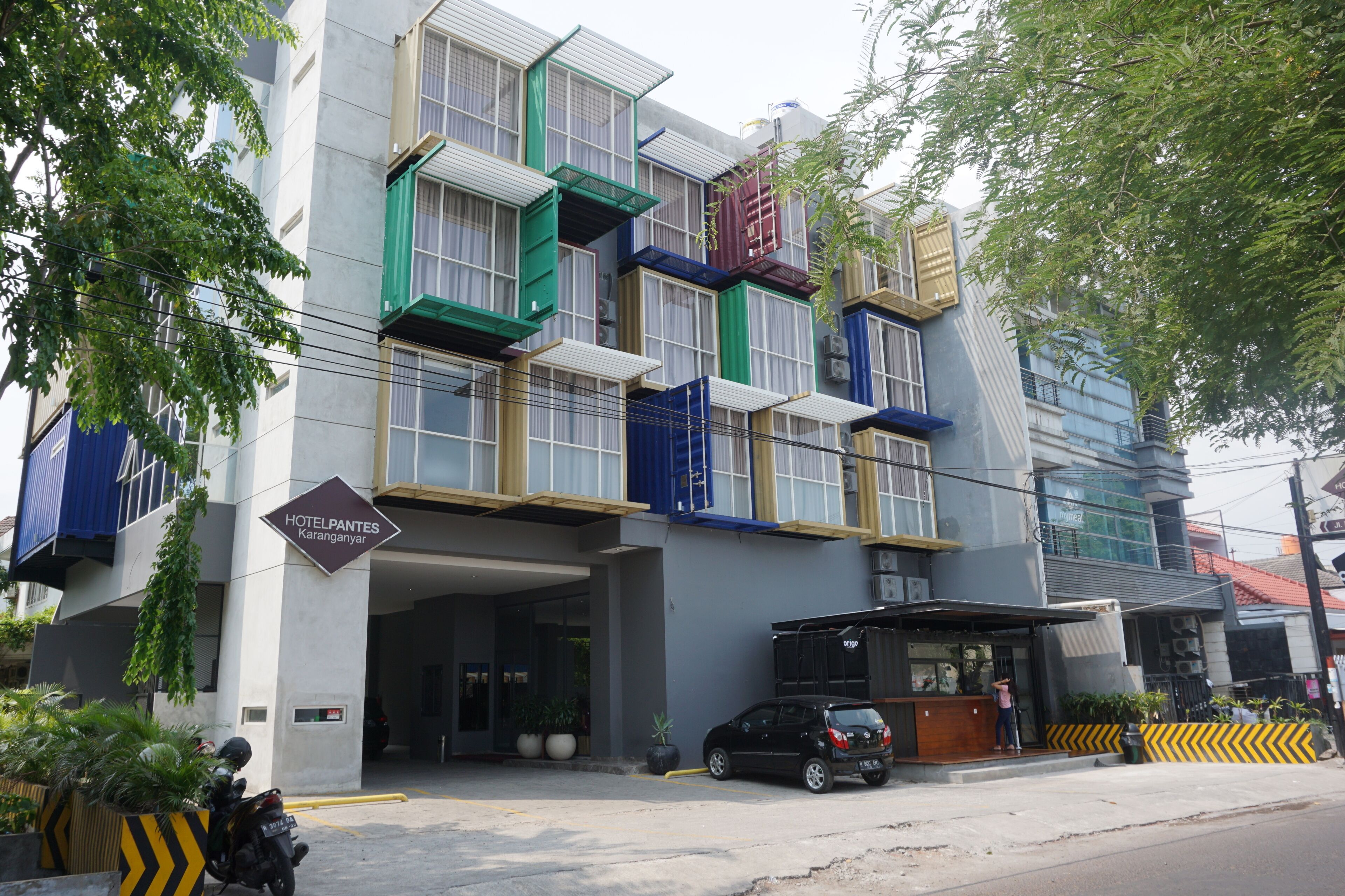 A hotel with a modern facade, multiple balconies, and a sign indicating it is a hotel.