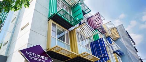 Experience the unique architecture of HotelPantes Karanganyar, featuring a striking facade with large windows and a flat design.