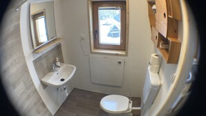 Une petite salle de bain comprenant un lavabo, des toilettes et une fenêtre.