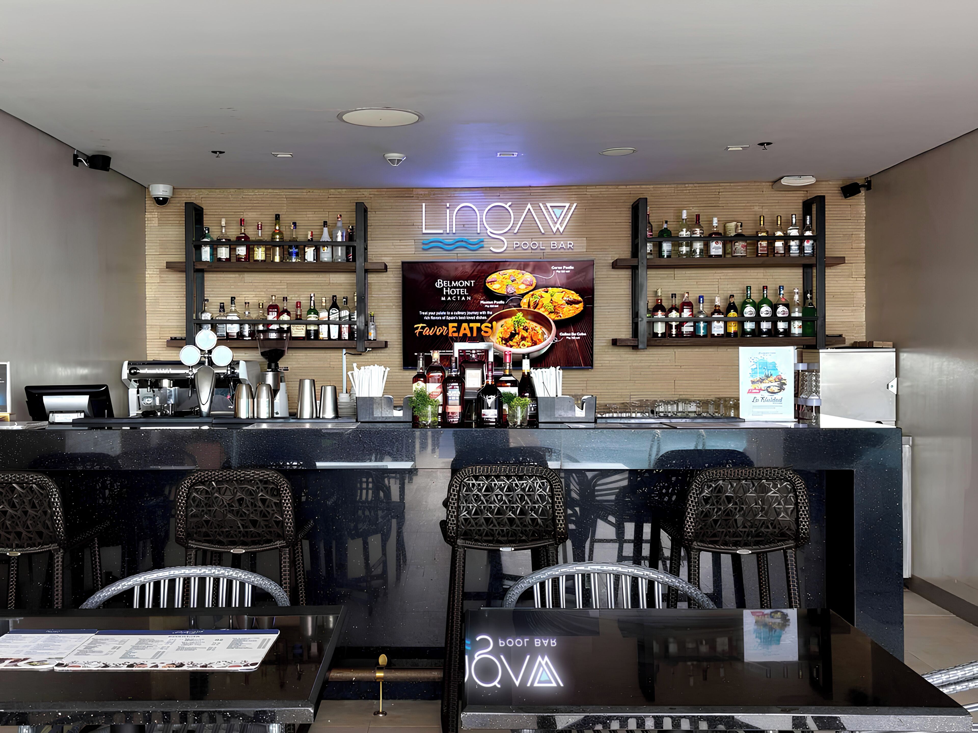 A bar area with a sign reading "LIONAW POOL BAR" and a menu board advertising "BELMONT HOTEL MACATAN".