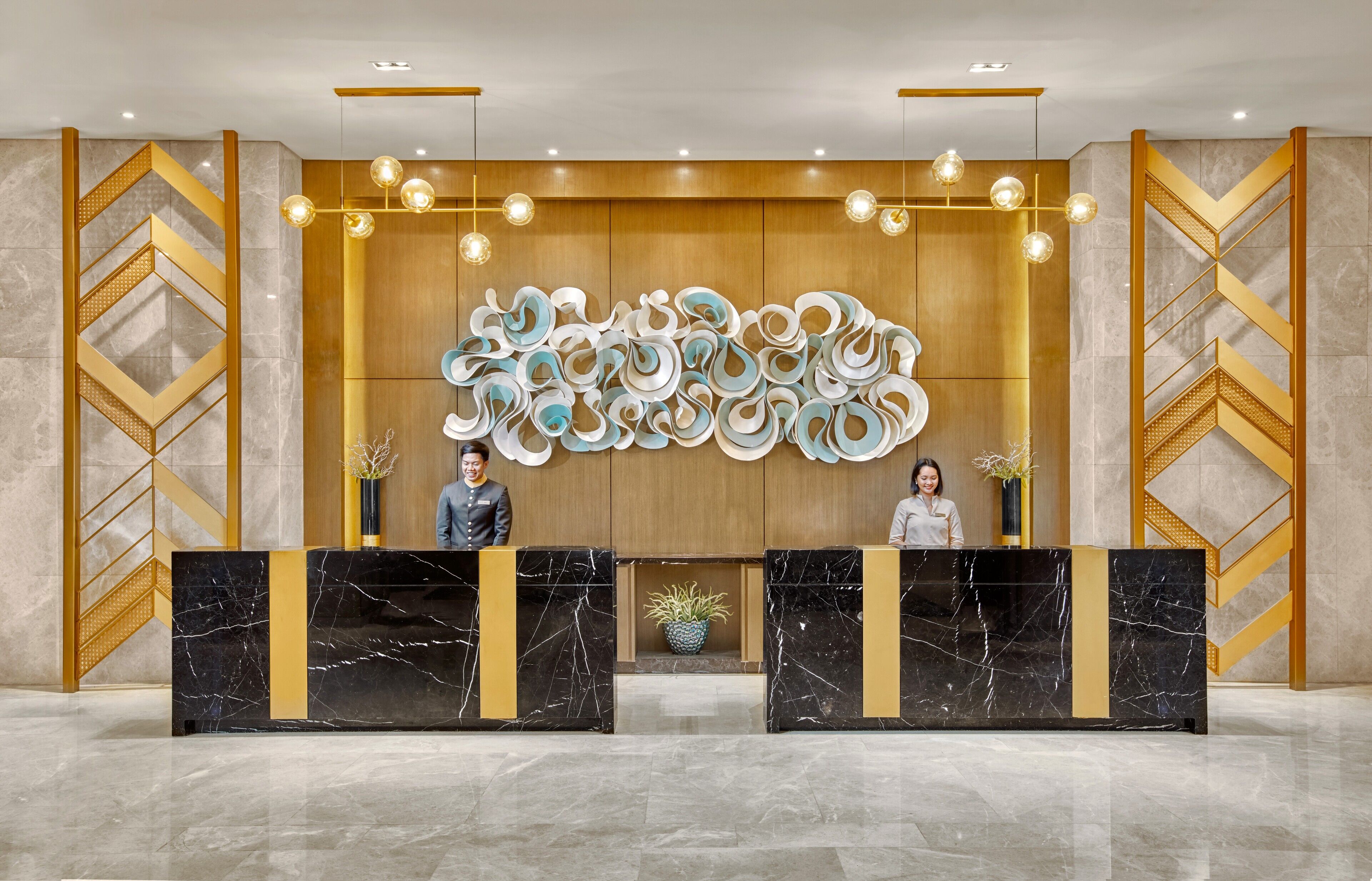 A reception area with a marble reception desk, a large abstract wall art piece, and a wooden panel backdrop.