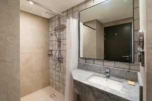 Ein modernes Badezimmer mit Dusche, Waschbecken und Spiegel.