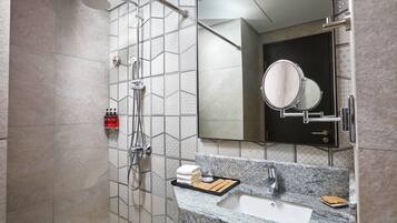 A modern bathroom with a shower, sink, and mirror.