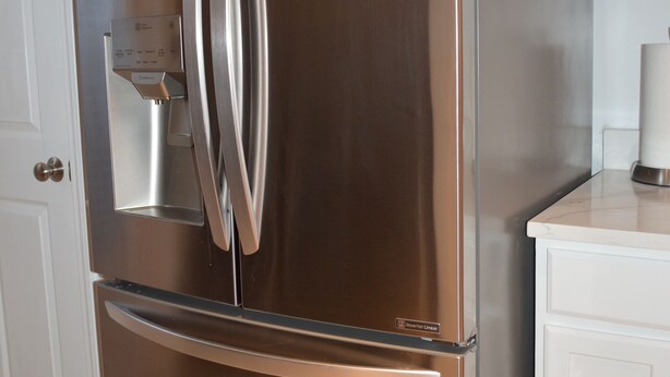 A stainless steel refrigerator with a water dispenser, built-in oven, and a freezer compartment.
