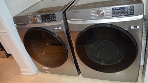 A Samsung front-loading washer and dryer unit with a control panel and a digital display.