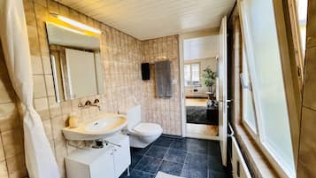 Een bad/douchecombinatie, een haardroger, handdoeken, shampoo