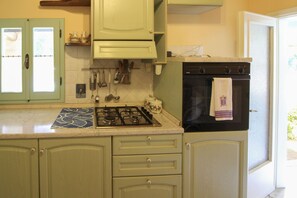 A kitchen with a gas stove, oven, and cabinets.