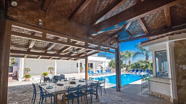 An outdoor dining area with a pool and lounge chairs. - Papas Family Villa with Private Pool WheelChair accessible (Paralimni)