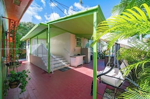 A house with a covered porch, a staircase, and a kitchen area.