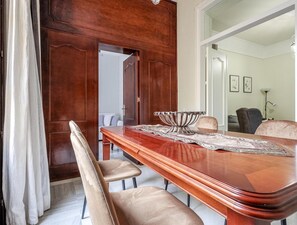 Een eethoek met een houten tafel, beige stoelen en een decoratieve schaal als middelpunt.