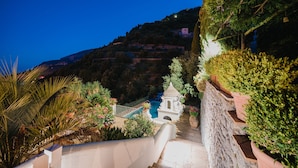 A nighttime view of a hillside with a swimming pool, a small gazebo, and a staircase leading up. - Villa la Campanella in Ravello (Scala)