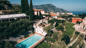 An aerial view of a coastal resort with a swimming pool, terraced gardens, and traditional Mediterranean architecture. - Villa la Campanella in Ravello (Scala)