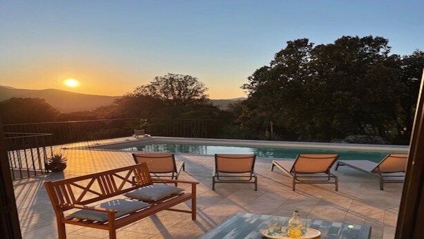 A patio with a pool, wooden furniture, and a view of the sunset. - Maison récente avec piscine privée à la campagne. (Urtaca)