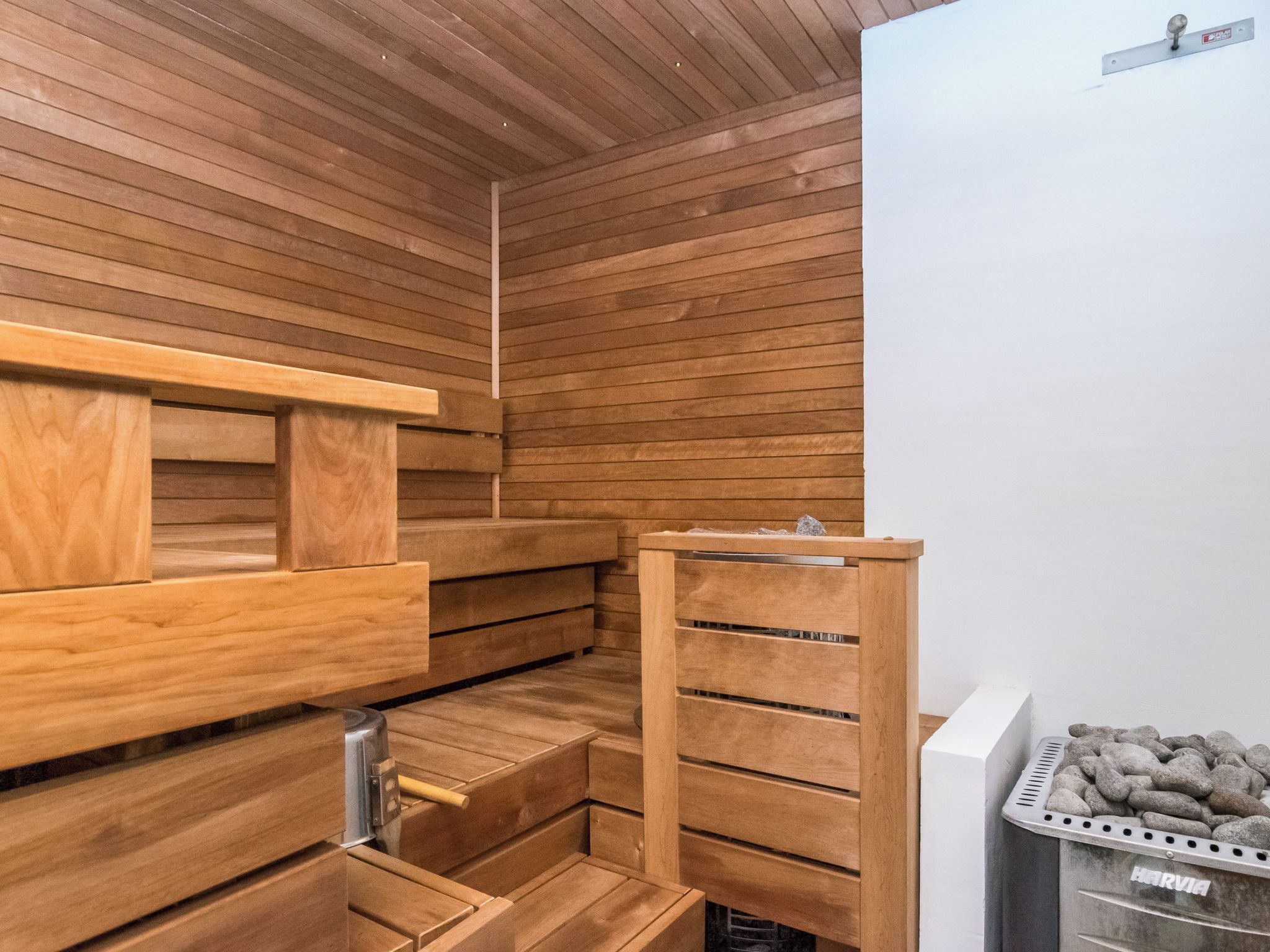 Een sauna met houten banken en een stenen muur.