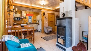 Un intérieur de chalet chaleureux comprenant un coin repas, une cuisine et une cheminée.