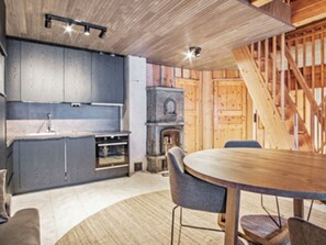 A kitchen with a built-in oven, a wooden table, and chairs.