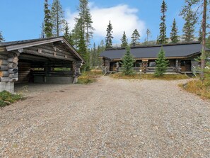 Ein rustikales Blockhaus mit Kiesweg, der zum Holzhaus führt.