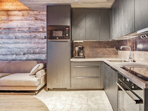 A compact kitchen with a built-in oven, a coffee maker, and a sink.