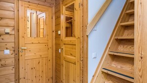 A wooden interior with a staircase and two doors leading to other rooms.