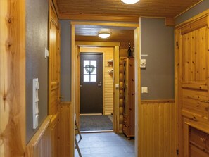 A wooden hallway with a door at the end, a small window, and a light fixture on the ceiling. - Antura b by Interhome (Pelkosenniemi)