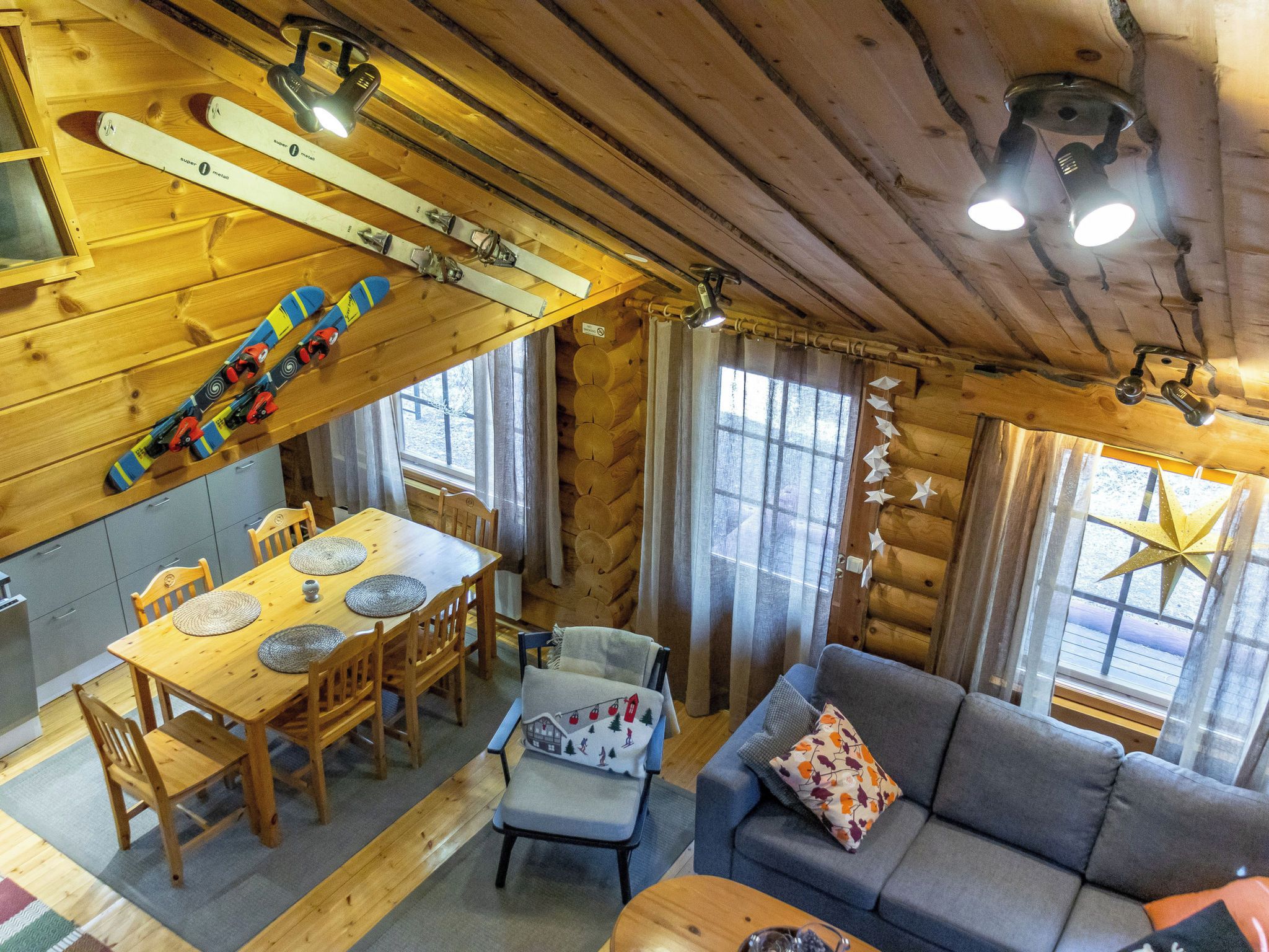 En mysig stuga med en matplats, en soffa och skidutrustning.