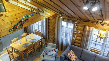 En mysig stuga med en matplats, en soffa och skidutrustning.