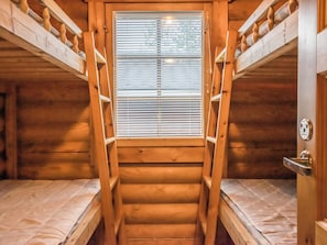 A wooden staircase leading to a window with blinds, flanked by bunk beds. - Pyhä-rasti by Interhome (Pelkosenniemi)
