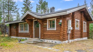 A log cabin with a front porch, a chimney, and a number '16' sign.