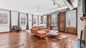 Un salon spacieux avec un canapé en cuir, une table basse et une cheminée.