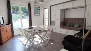 A modern living room with a dining table, sofa, and a cabinet. - Quiet house near Domino market (Saint-Georges-d'Oléron)