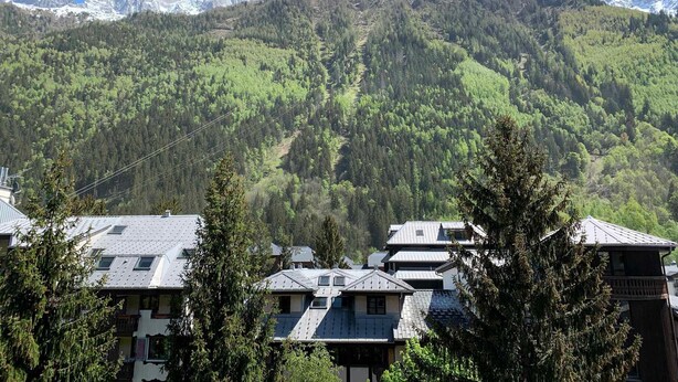 A mountain village with houses in the foreground and snow-capped peaks in the background. - Studio in Chamonix with balcony, 4 people (Chamonix-Mont-Blanc)