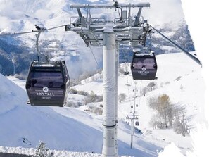 A ski lift with cabins labeled "SKYVAL" in a snowy mountainous area.