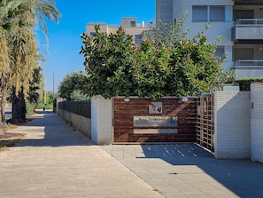 A gated entrance to a residential building with a sign indicating 'Nova Torredembarra Residencial' and 'Bloques 34, 35, 36, 37.'