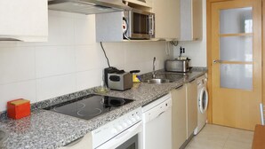 A modern kitchen with a built-in microwave, toaster, and stainless steel sink.