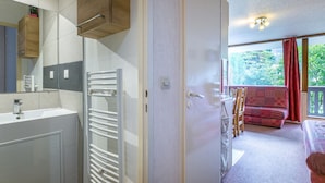 Un baño moderno con lavamanos, toallero y espejo.