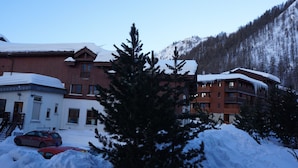 Un edificio cubierto de nieve con un telesilla al fondo.