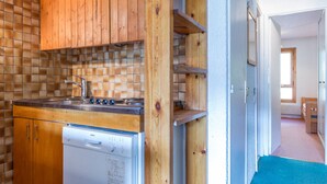 A compact kitchen with wooden cabinets, a Bosch dishwasher, and a tiled backsplash. - 3-room apartment ski-in ski-out, 6 pers., south, La Daille (Val-d'Isère)