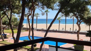 A pool area with a view of the beach and ocean. - Sea-front apartment with pool and private parking in Torredembarra (Torredembarra)