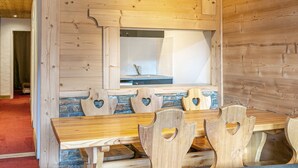 Un intérieur en bois, avec un mur en pierre et une table en bois entourée de chaises.