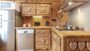 Una cocina con armarios de madera, un refrigerador de acero inoxidable y un lavavajillas.