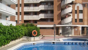 Una piscina circondata da un edificio in mattoni con diversi balconi.