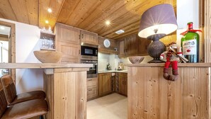 Una cocina con gabinetes de madera, una zona de bar y un peluche.