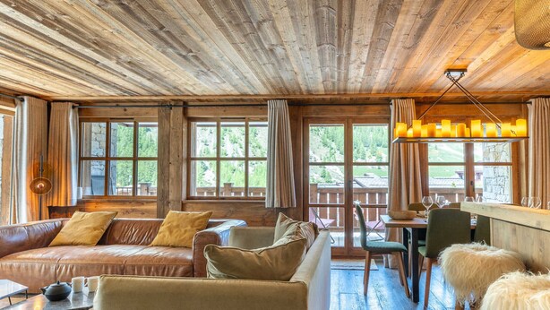 A rustic cabin interior with a wooden ceiling, leather sofas, a dining area, and large windows. - Luxury apartment with pool, WiFi, and parking in Val-d'Isère (Val-d'Isère)