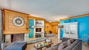 A living room with a fireplace, a sofa, a coffee table, and a television.